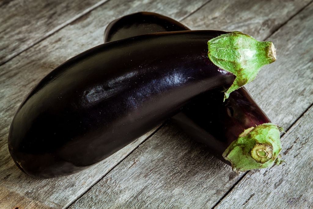 Two raw organic eggplant on old rustic wooden background